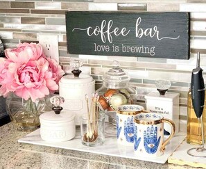 A coffee bar setup with a sign that reads 'coffee bar love is brewing.' - Decorative 3 BR Townhome Near Las Colinas (Irving)
