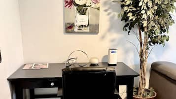 A workspace with a desk, chair, and a potted plant.