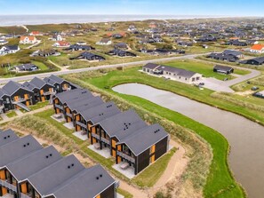 Een moderne woonwijk met meerdere huizen en een groot wateroppervlak.