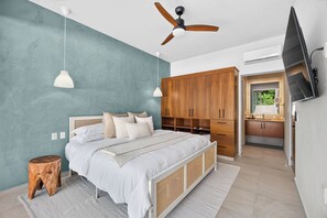 A bedroom with a bed, bedside tables, a wardrobe, a ceiling fan, and a television. - Family-Friendly Apartment in Puerto Vallarta (Puerto Vallarta)