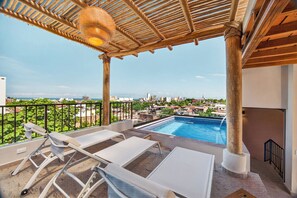 A rooftop terrace with a pool, lounge chairs, and a view of the city. - Family-Friendly Apartment in Puerto Vallarta (Puerto Vallarta)