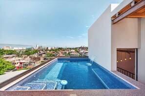 A rooftop swimming pool with a city view, a water slide, and a lounge area. - Family-Friendly Apartment in Puerto Vallarta (Puerto Vallarta)