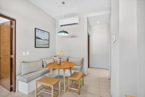 A modern living room with a sofa, a round table, and two chairs. - Family-Friendly Apartment in Puerto Vallarta (Puerto Vallarta)