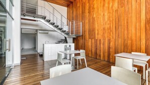 Ein modernes Interieur mit Holzboden, weißen Möbeln, einer Treppe und einer Holzwand.