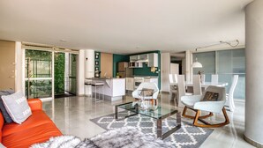 A modern living room with a glass coffee table, a sofa, and a dining area with chairs. - Reforma Elegance · A Pasos del Ángel (Ciudad de México)