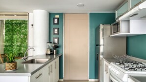 A modern kitchen with stainless steel appliances, a sink, and a stove. - Reforma Elegance · A Pasos del Ángel (Ciudad de México)