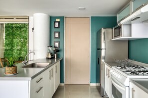 Een moderne keuken met roestvrijstalen apparatuur, een spoelbak en een fornuis.