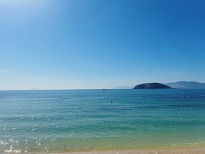 Vista despejada de un mar tranquilo con una montaña distante y un bote.
