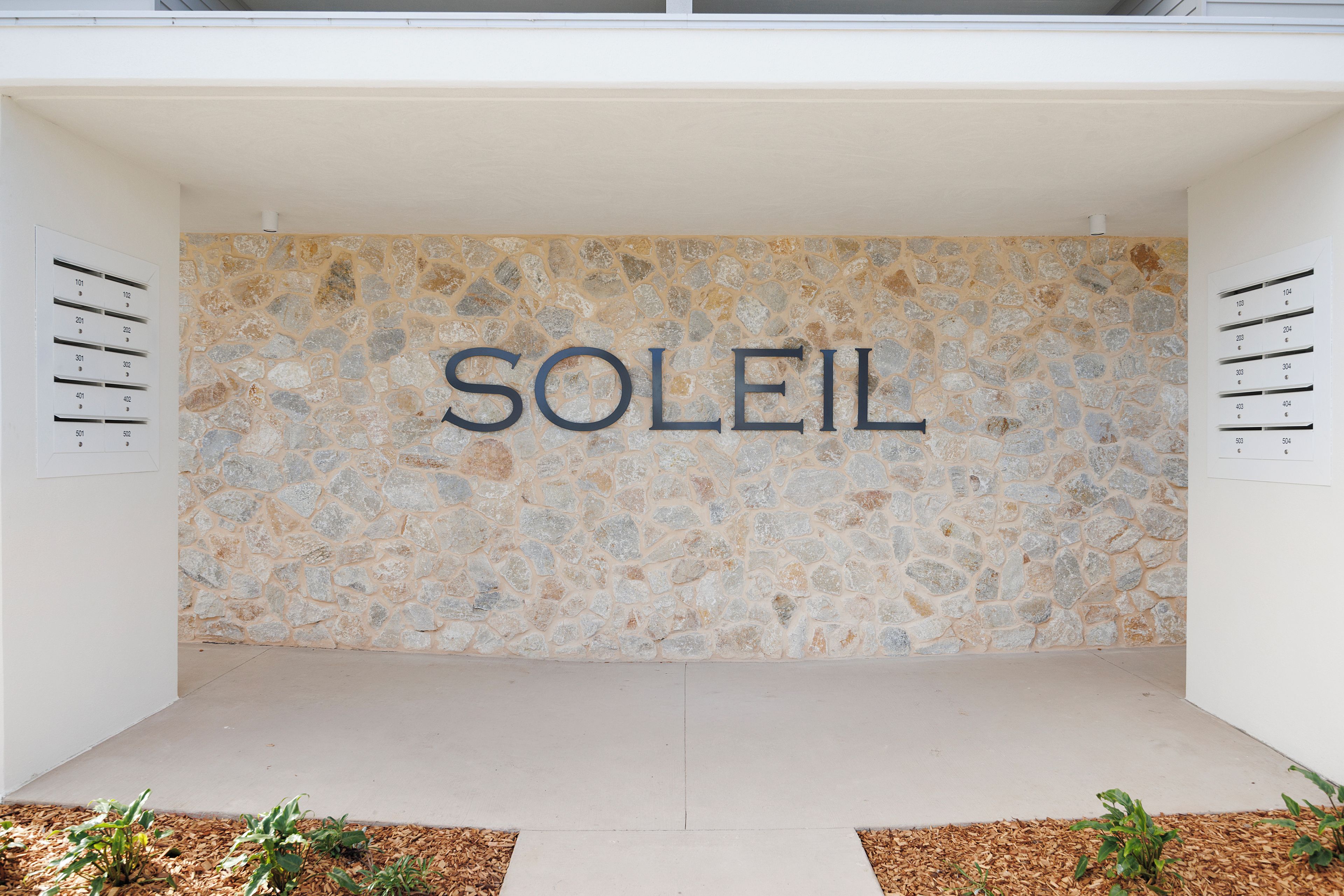 A stone wall with the word 'SOLEIL' in large letters.