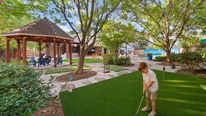 Un parcours de golf doté d’un pavillon, d’un green d’entraînement et d’une pelouse bien entretenue.