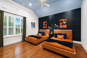 A bedroom with two beds, a ceiling fan, and a window with blinds. - Epic TX Stay: Pickleball•Golf Sim•Theater•Sleeps24 (Spring)