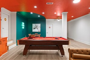 A pool table in a room with teal and white walls, a neon sign, and a framed artwork. - Epic TX Stay: Pickleball•Golf Sim•Theater•Sleeps24 (Spring)