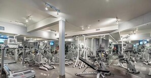 A gym with various exercise machines, mirrors, and a large mirror wall. - Luxury Rockies Escape - Pool & HotTub - King Bed - AC! (Canmore)