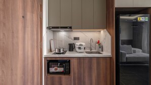 Una cocina compacta con microondas integrado, hervidor y tostadora.
