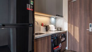 Una cocina moderna con lavadora integrada, refrigerador y microondas.