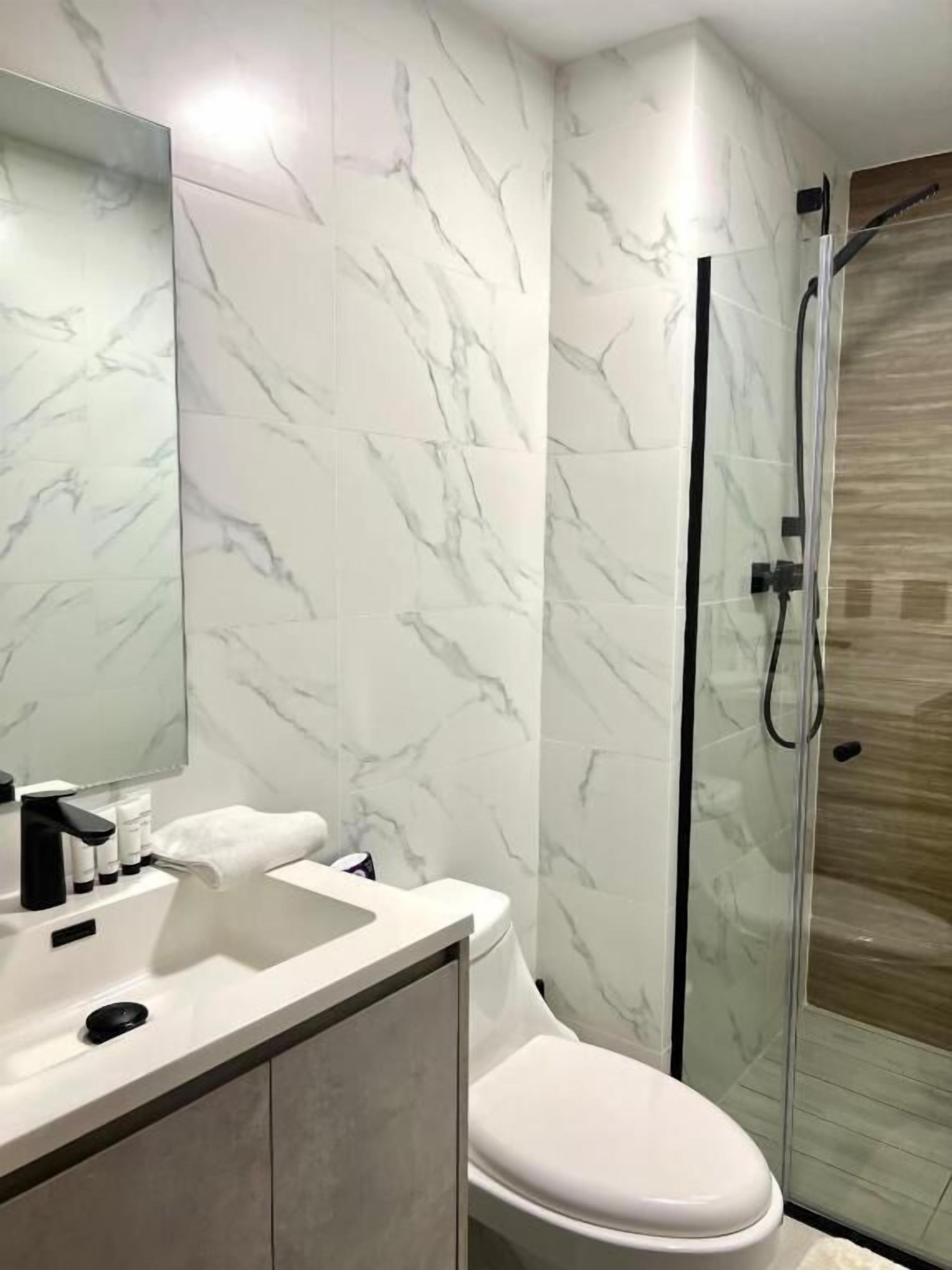 Appartement, balcon, vue ville | Salle de bain | Douche, articles de toilette gratuits, sèche-cheveux, chaussons