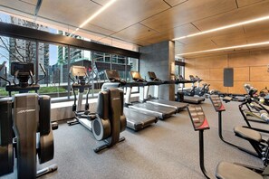 Ein Fitnessstudio mit Laufbändern, Crosstrainern und Kraftgeräten.