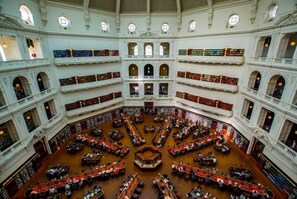 Eine mehrstöckige Bibliothek mit vielen Bücherregalen und Sitzbereichen.