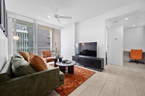Ein modernes Wohnzimmer mit einer Couch, einem Couchtisch und einem Fernseher.