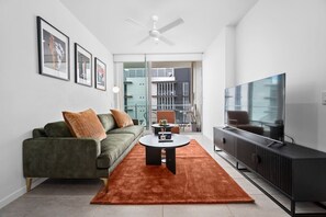 Ein modernes Wohnzimmer mit Sofa, Couchtisch und Fernseher.