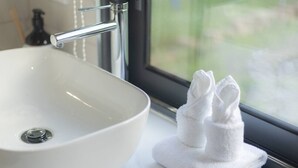 A white sink with a chrome faucet and a window view. - Great Value Renoted Studio| Near Griffith & Shops (Nathan)