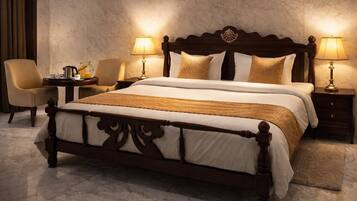 A hotel room with a large bed, two bedside tables, a chair, and a lamp.