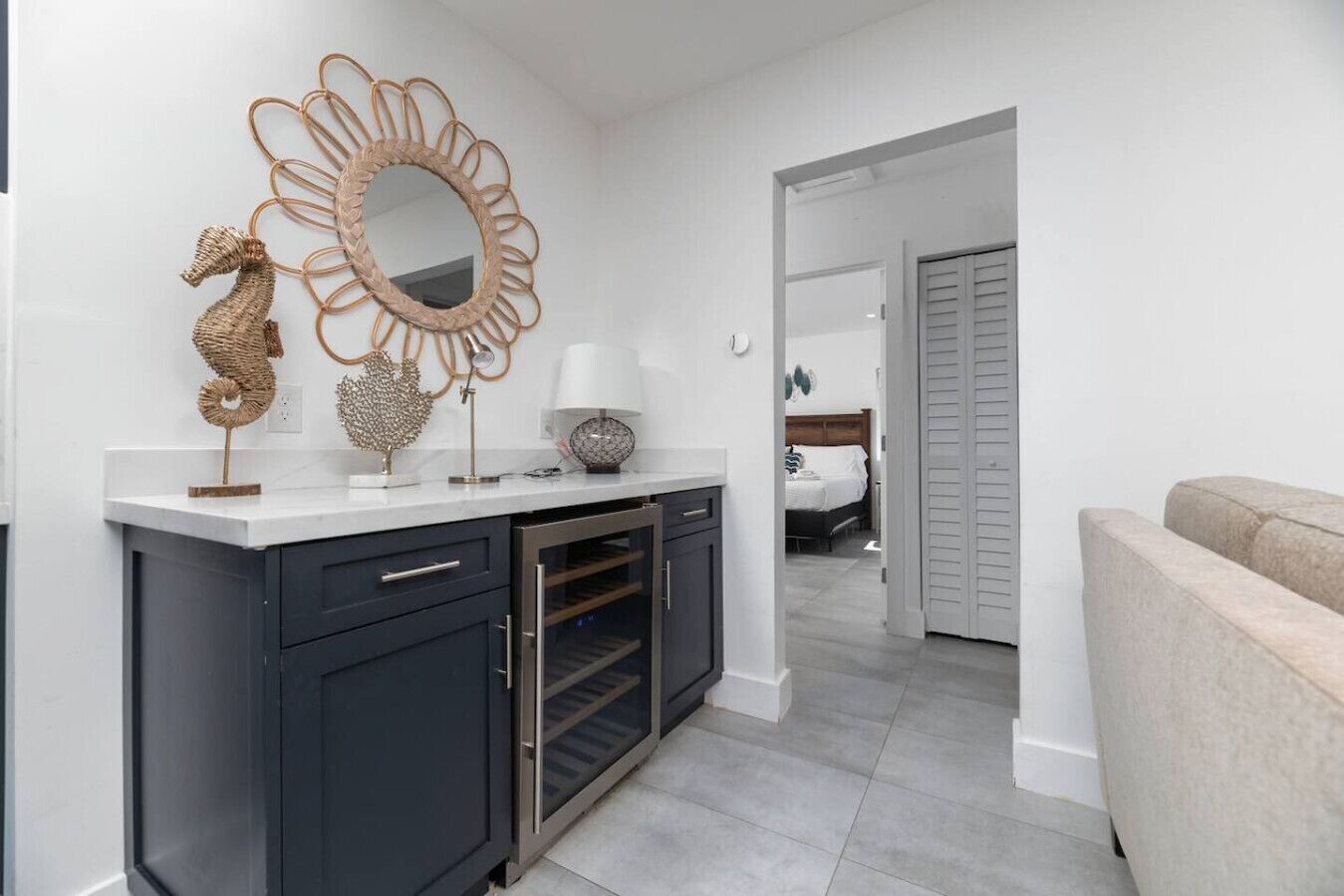 A modern kitchen with a built-in oven, a dark cabinet, and a decorative mirror with a seahorse design.