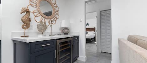 A modern kitchen with a built-in oven, a dark cabinet, and a decorative mirror with a seahorse design.
