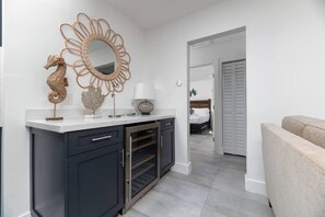 A modern kitchen with a built-in oven, a dark cabinet, and a decorative mirror with a seahorse design. - Your Downtown Getaway (Fort Lauderdale)