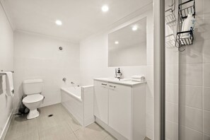 Ein modernes Badezimmer mit Toilette, Badewanne und Waschbecken.