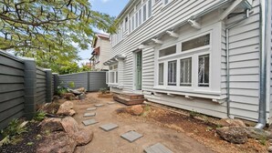 Asuinrakennus, jossa on kivetty patio, kivestä tehdyt portaat ja aidattu piha.