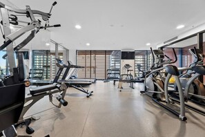 Ein modernes Fitnessstudio mit verschiedenen Cardiogeräten, Krafttrainingsgeräten und Kurzhanteln.