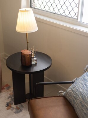 A round black table with a lamp, a decorative container, and a glass. - Stylish 4BR Family Retreat | Peaceful & Convenient (Park Ridge)