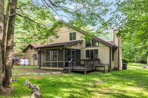 Ein zweigeschossiges Haus mit Veranda, Garage und überdachter Terrasse.