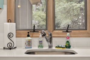 Bright kitchen workspace with wooded views. - Harmony Pines | Hot Tub & Beach Access (Lake Harmony)