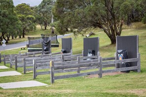 A park with a wooden fence, a trampoline, and a target area. - Rose Creek Chalet: Cosy 2BR w/ Resort Facilities, Crackenback Resort NSW (Crackenback)