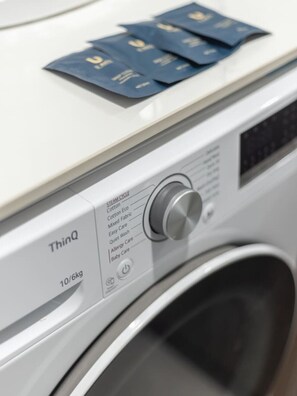 A front view of a washing machine with a control panel and a label indicating 'ThinQ' and '10/6kg'. - Great Value|Renovated Studio|Prime Location|Aircon (Nathan)