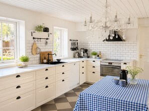 A modern kitchen with white cabinetry, a checkered tablecloth, and a chandelier. - "Edin" - 4km from the sea by Interhome (Løkken)