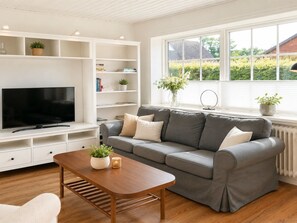 A modern living room with a grey sofa, wooden coffee table, and white shelving unit. - "Edin" - 4km from the sea by Interhome (Løkken)