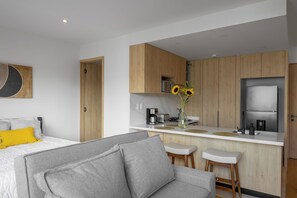 Eine moderne Küche mit Holzschränken, einem eingebauten Backofen und einem Edelstahl-Kühlschrank.