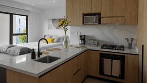 A modern kitchen with a central island, wooden cabinets, a microwave, a coffee maker, and a toaster. - Reforma Elegance · A Pasos del Monumento & Ángel (Ciudad de México)