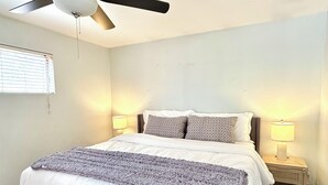 A bedroom with a bed, two bedside lamps, a ceiling fan, and a window with blinds. - Scottsdale Paradise w/ Fire Pit & BBQ, Heated Pool & Spa, Mini Golf & Cornhole (Scottsdale)