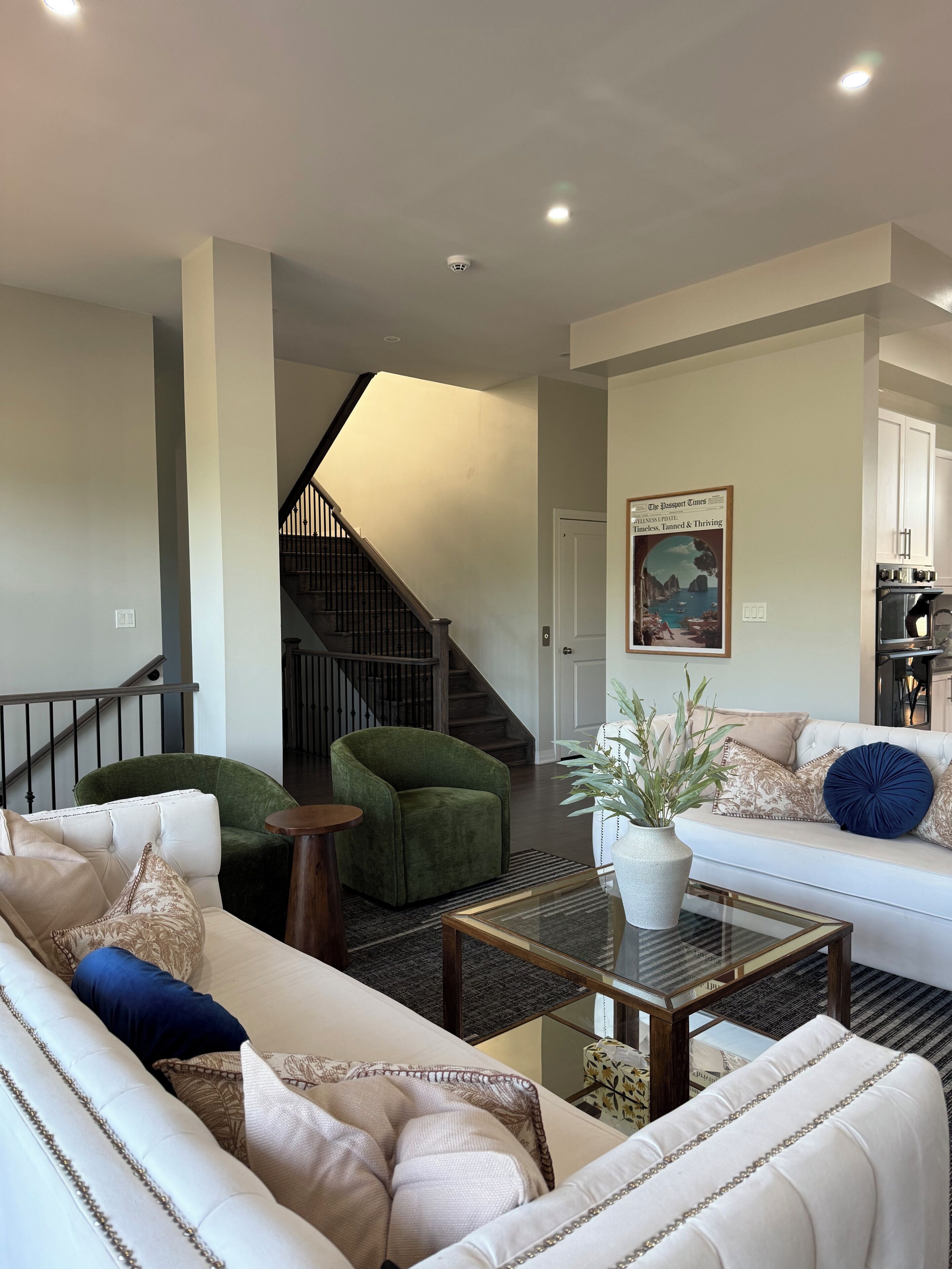 Una sala de estar moderna con una escalera, un comedor y una cocina.