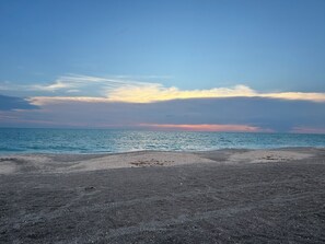 Una platja amb cel clar i mar tranquil·la.