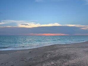 Ein Strand mit blauem Himmel und ruhiger See.