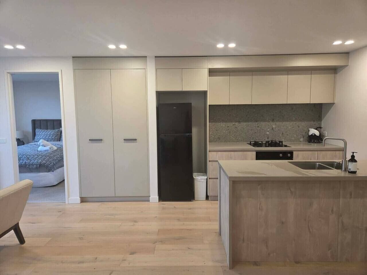 A modern kitchen with a central island, built-in cabinets, and a separate dining area.