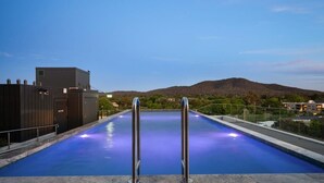 A swimming pool with a view of a mountain range, surrounded by a fence and buildings. - Classy 2b2b apartment / Northbourne Ave (Dickson)