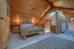 A cozy attic bedroom with a wooden bed, a nightstand, a dresser, and a radiator. - Beautiful Family Home with a Pool, Nestled Between the Lake and the Mountains (Lathuile)