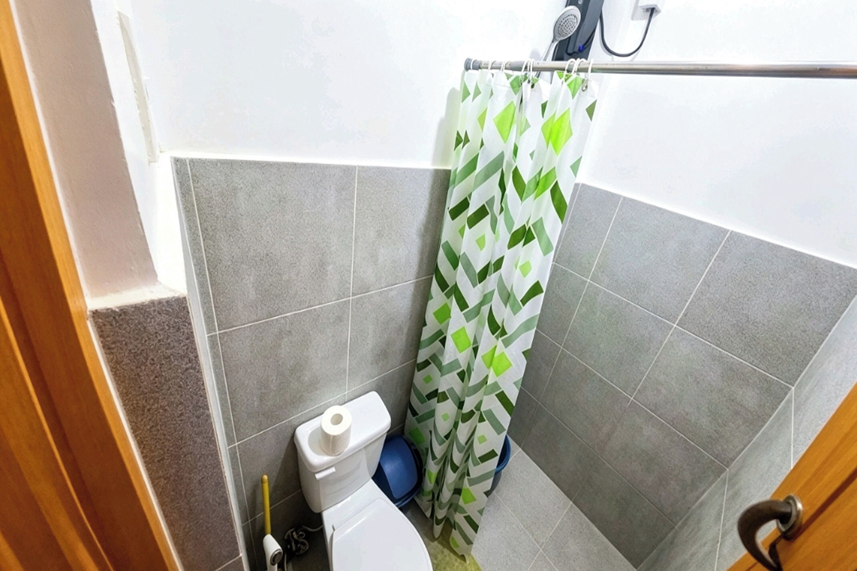 Un baño con inodoro, cortina de ducha y lavamanos azul.