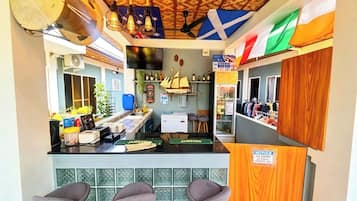 A bar area with stools, a counter, and a sign indicating no entry.